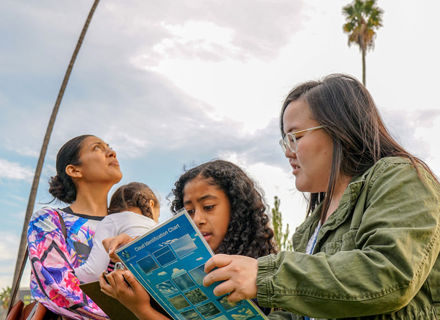 kids participating in a cloud identification class outside the library