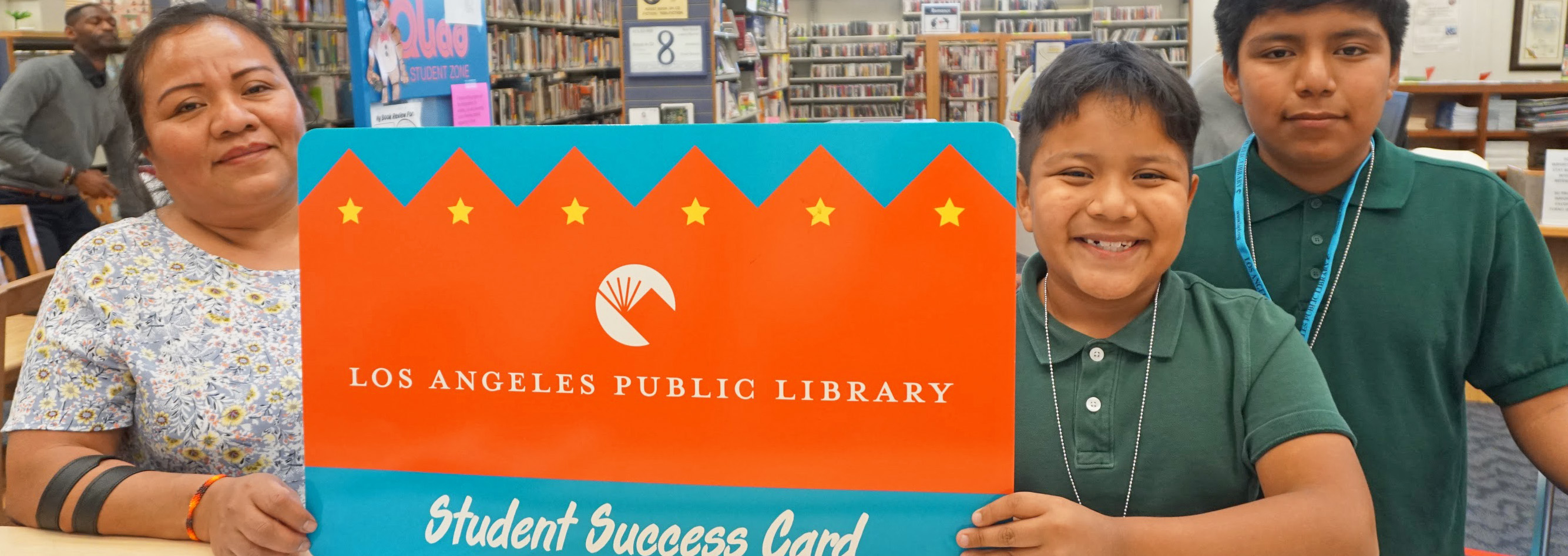 students and their mother holding a library card