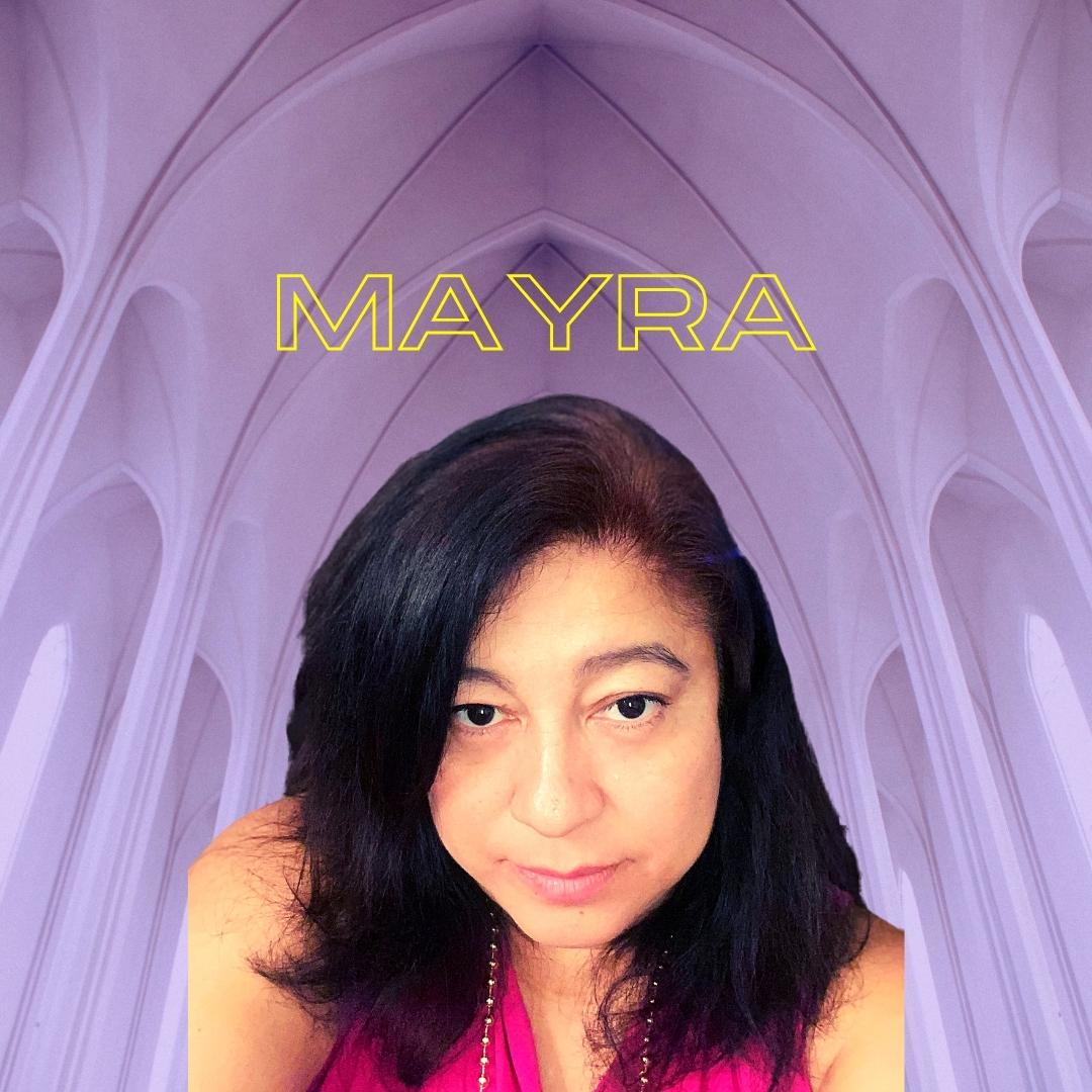Mayra looks thoughtful and intense in front of a vaulted ceiling.