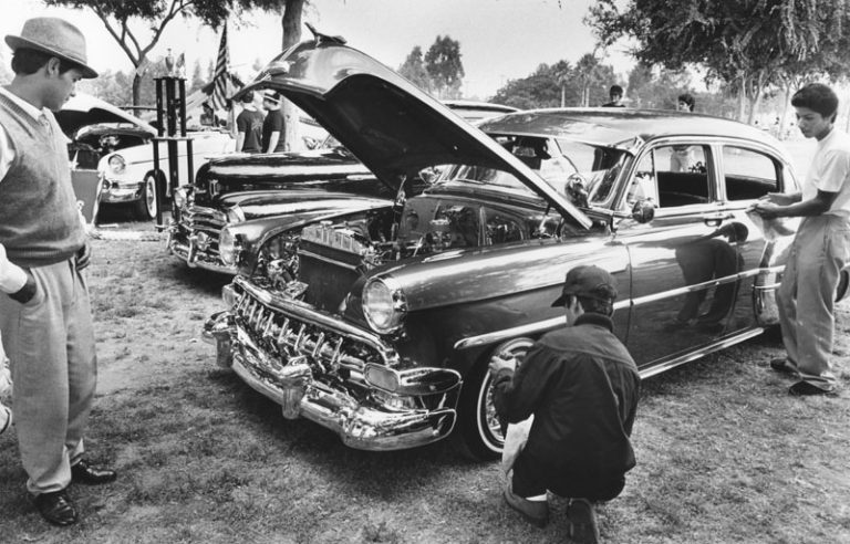 A collection of classic lowrider cars is displayed in Huntington Park for the Fourth of July. (Anne Knudsen/Herald-Examiner Collection, July 4, 1982)