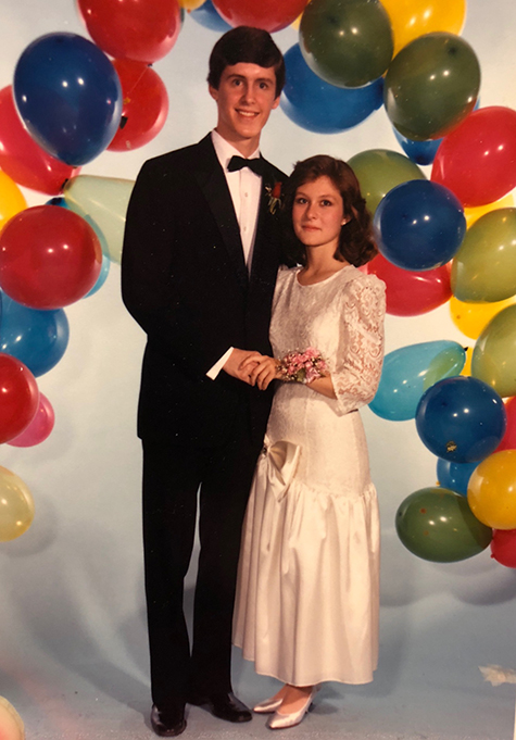 Two teens posing for prom with balloons in the background