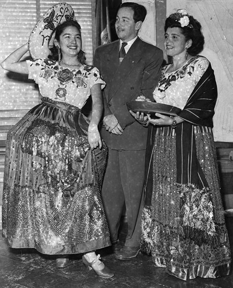 Louise Orona (left), who is showing Alberto Mecerra Sierra, consul of Mexico, one of the Latin-American dancing steps, as Maria Bustos looks on. 