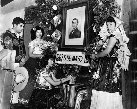 historic Avila House on Olvera Street participants placed flowers before a portrait of Gen. Ignacio Zaragaza, who overthrew the Austrian leader. In the group are: Miguel Garcia, Margarita Garcia, Virginia Henandez, and Beatrice Aguirre. 