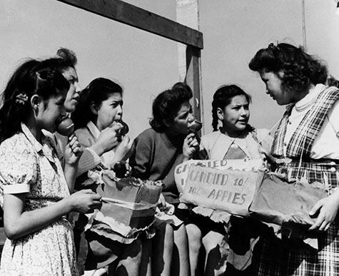 Girls share candied apples at a Cinco de Mayo celebration at Ramona Gardens.