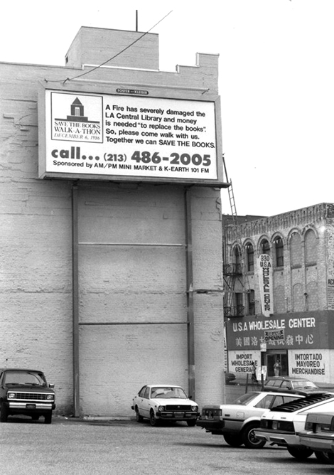 A downtown billboard encourages community members to participate in the save the library fund.