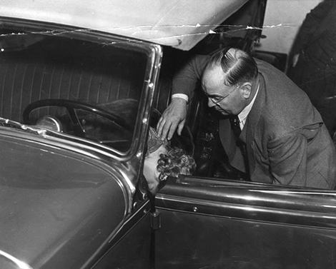 Captain Bert Wallis of the police homicide squad makes a check of the position of Thelma Todd's body where it was found in her car.