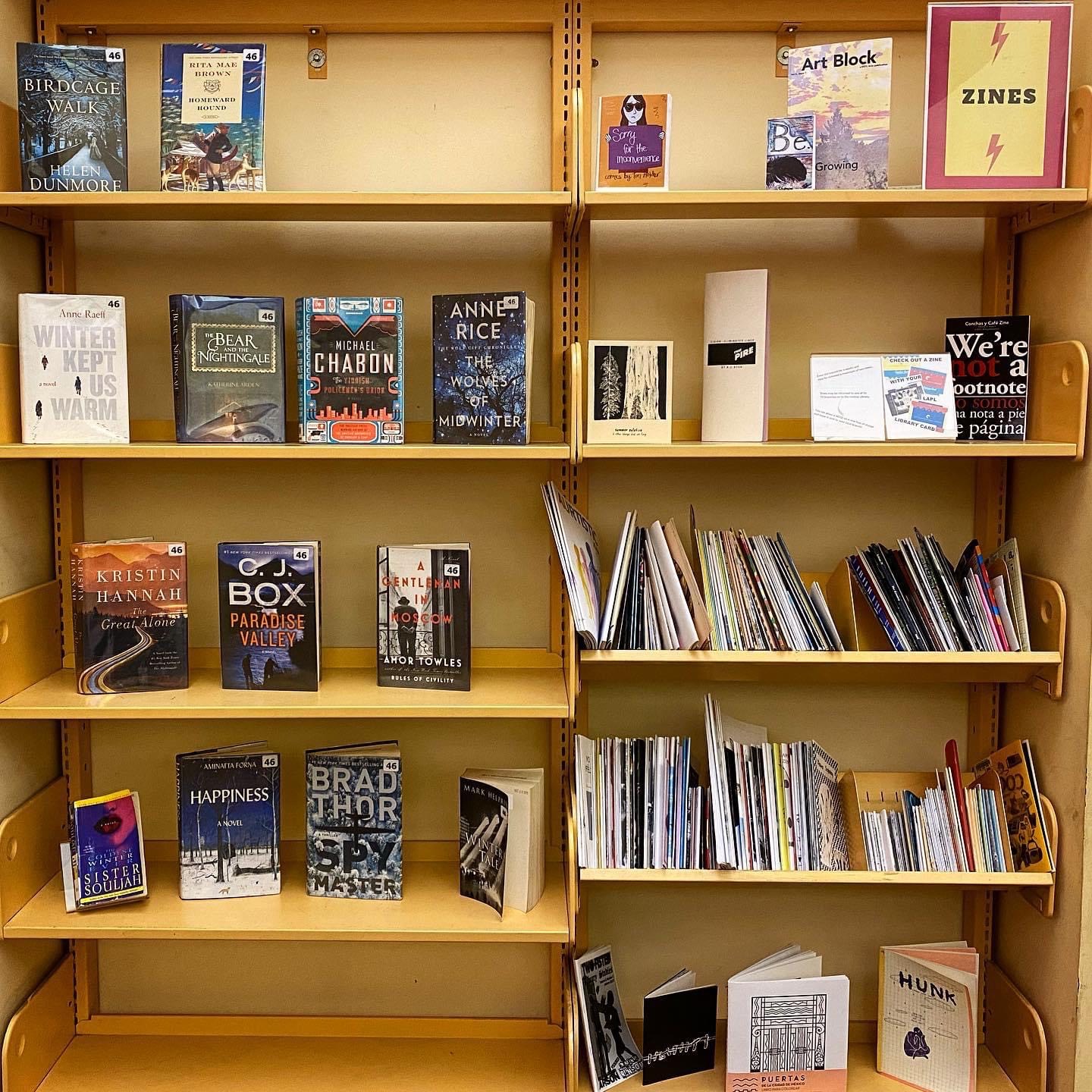 zine sign, and zines on a shelf