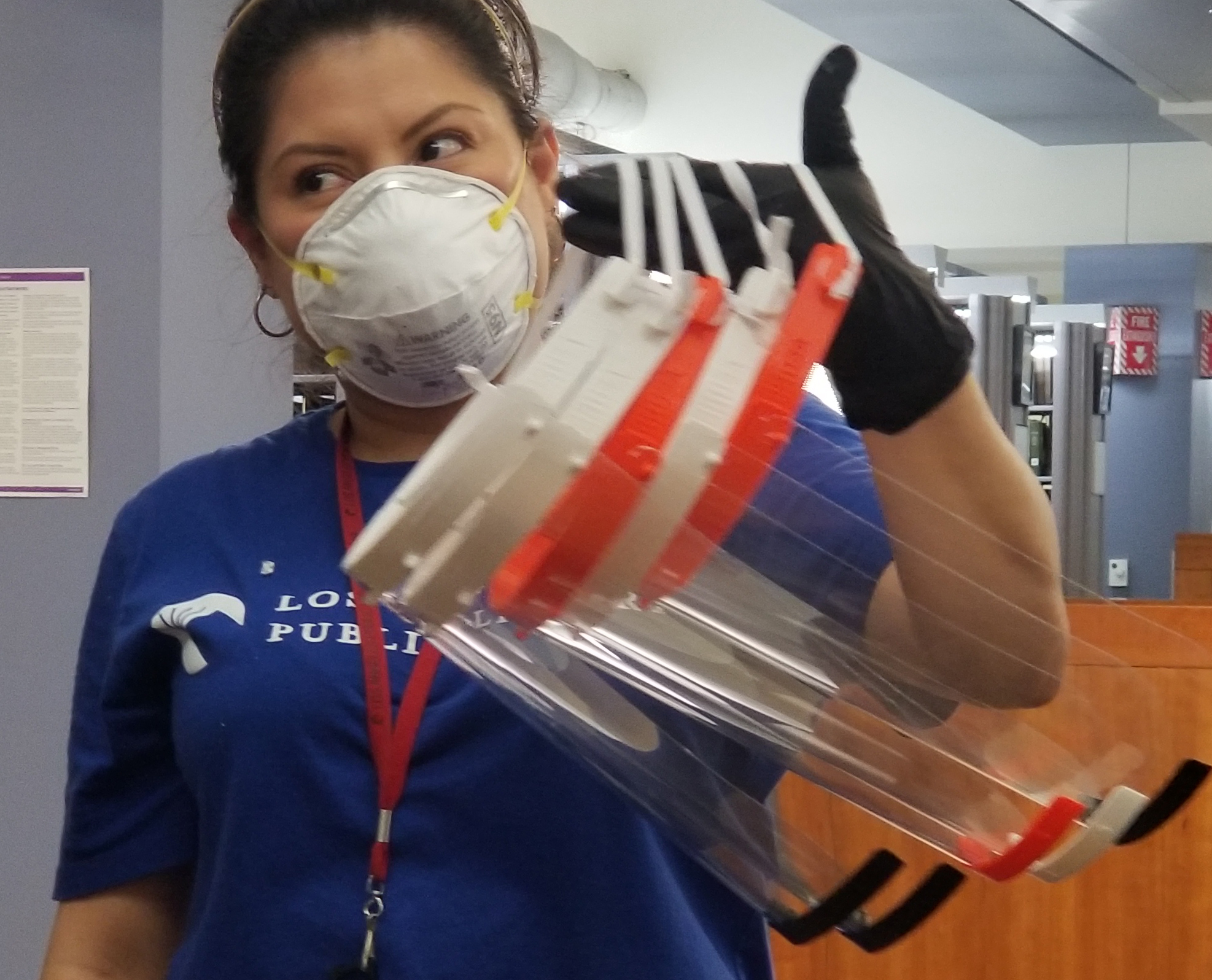 staff member holding an arm load of facemasks