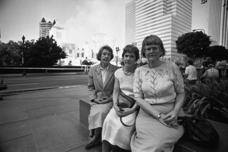 Librarians Kathleen Leidich, Helene Mochedlover, and Billie Conner sit solemnly across the street from Central Library as the fire rages