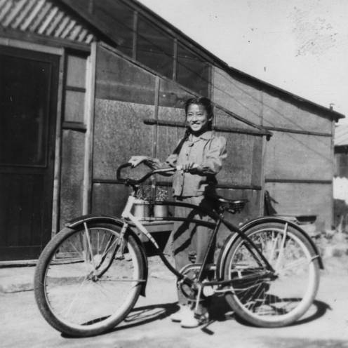 Japanese American girl with bicycle at internment camp