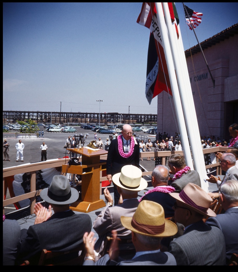 Undersecretary of the Navy Charles Sparks Thomas is featured standing near the podium. The gold telephone expecting a call from Vice President Richard M. Nixon can be seen on the podium