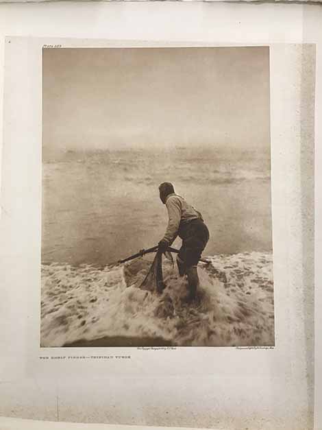 Yurok Native American man fishing for smelt with a large handheld net