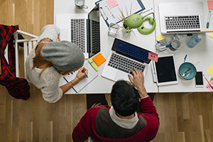 people working at a table with laptops and other tools