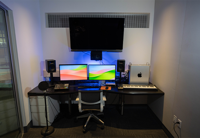 A studio space with two computer monitors and other equipment.