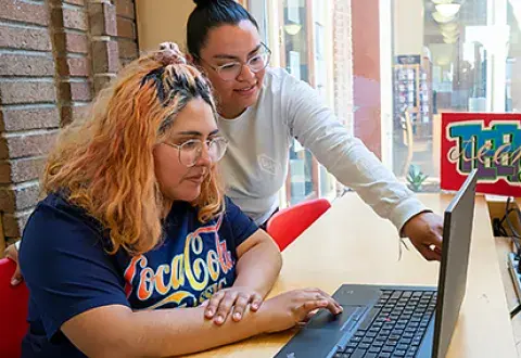 two young adults working at the computer
