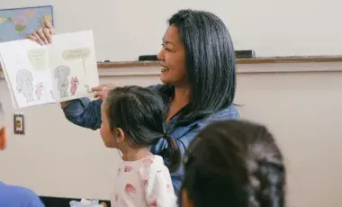 Woman reading a book to children