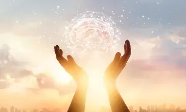 Two hands reach into the sky holding a ball of light