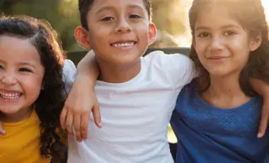 young children girls and boys smiling with arms around each other