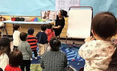 Volunteer reading to a group of kids. 