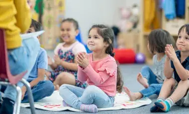 Toddlers seated on the floor listening to a story