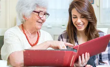 A person helping another person read a book.