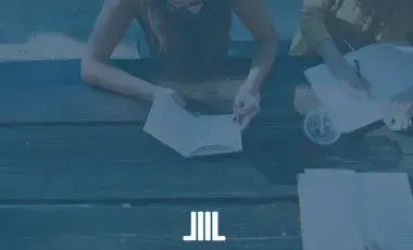 2 girls sitting on a bench writing in journals