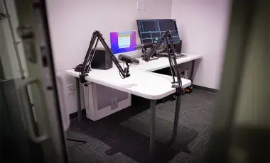 A podcast studio with desk and audio recording equipment
