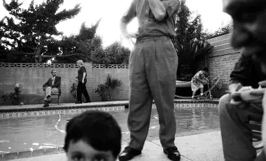 black and white photo of family by swimming pool