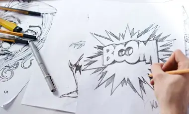 Close-up of hand drawing various graphic/comic sketches.