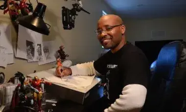 Animator Evan Burse posing at his desk