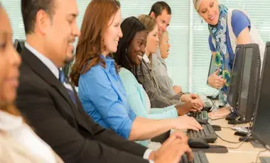 Men and women sitting and using computers