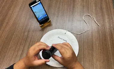 smart phone, paper plate, and person holding handheld microscope