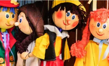 Four assorted marionettes, side-by-side, with yellow and green tops.