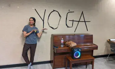 Photo of yoga teacher pointing to the word yoga