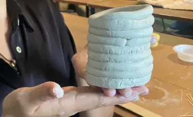 hands holding a clay sculpture