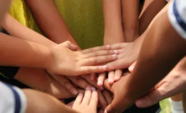 kids hands together in a group huddle