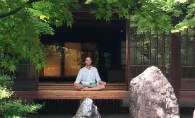Meditation guide seated on a platform
