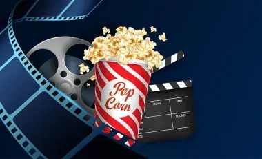 dark blue image with popcorn, film, and film canister in the forground