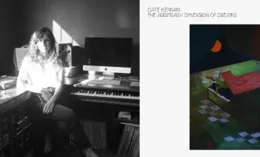 Keyboardist and synthesis Cate Kennan is pictured in front of her home studio. Next to her is the cover of her album, a painting of a piano with a being emerging under a moon. 