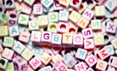 a pile of colorful letter beads with the initialism LGBTQ in the middle