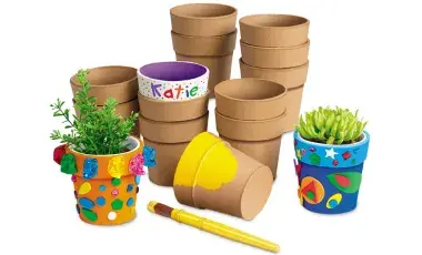stacks of small gardening pots, with several that are painted and decorated and a yellow paintbrush