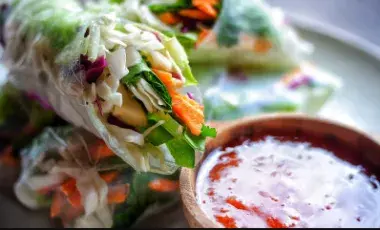 Spring rolls with a container of sauce