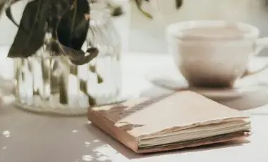 Soft journal beside coffee and flowers