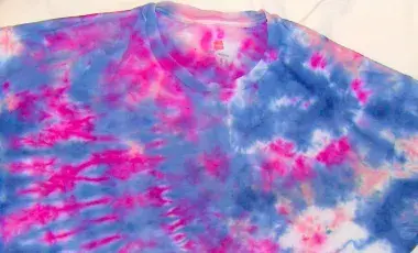 A vibrant tshirt that has been tie-dyed in pink and blue.