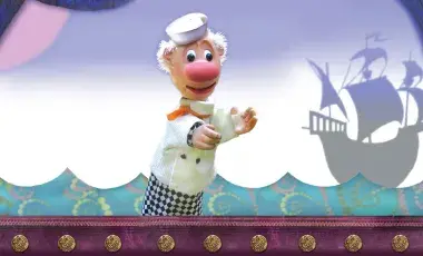 sailor puppet with a ship in the background