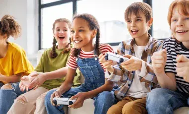 Young people sitting and playing video games with controllers in their hands.