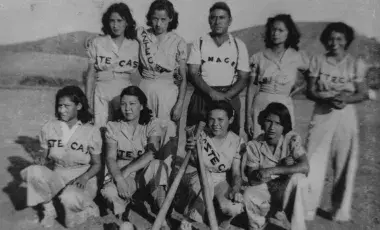 Group portrait of the Aztecas, a girls’ baseball team based in Pacoima, with their manager