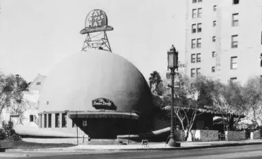 Exterior of a dome-shaped building with signage that reads "Eat in the hat" and "The Brown Derby"