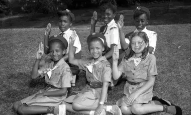 Local Girl Scout Juniors and Cadettes demonstrate the Girl Scout Sign, circa 1964.