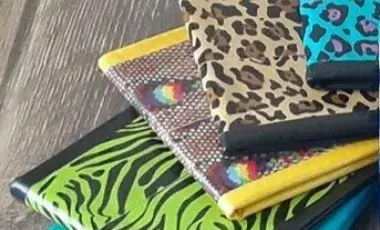 Five wallets of different colors and designs made of duct tape.